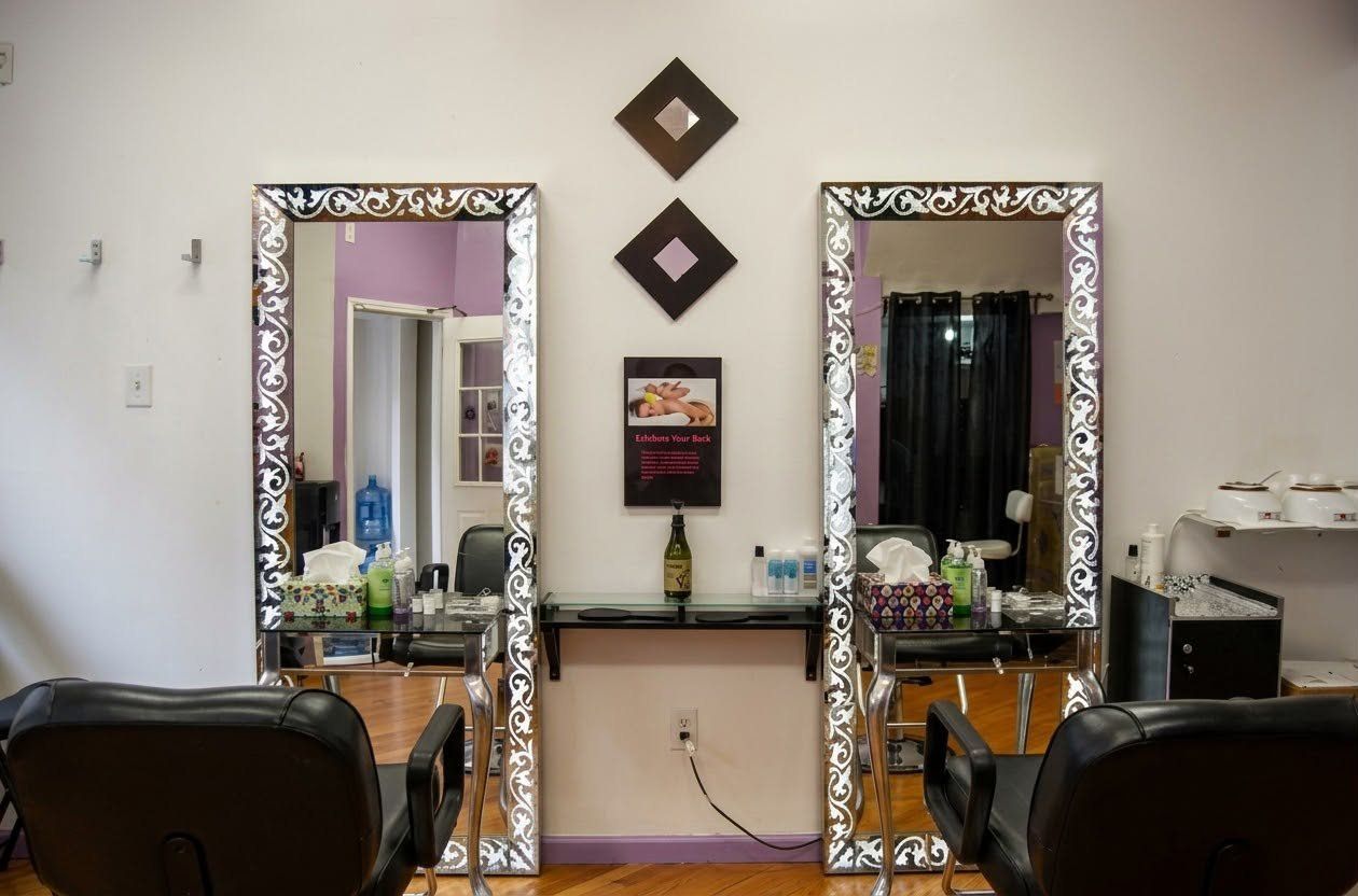 Two threading stations with silver framed mirrors and black salon chairs